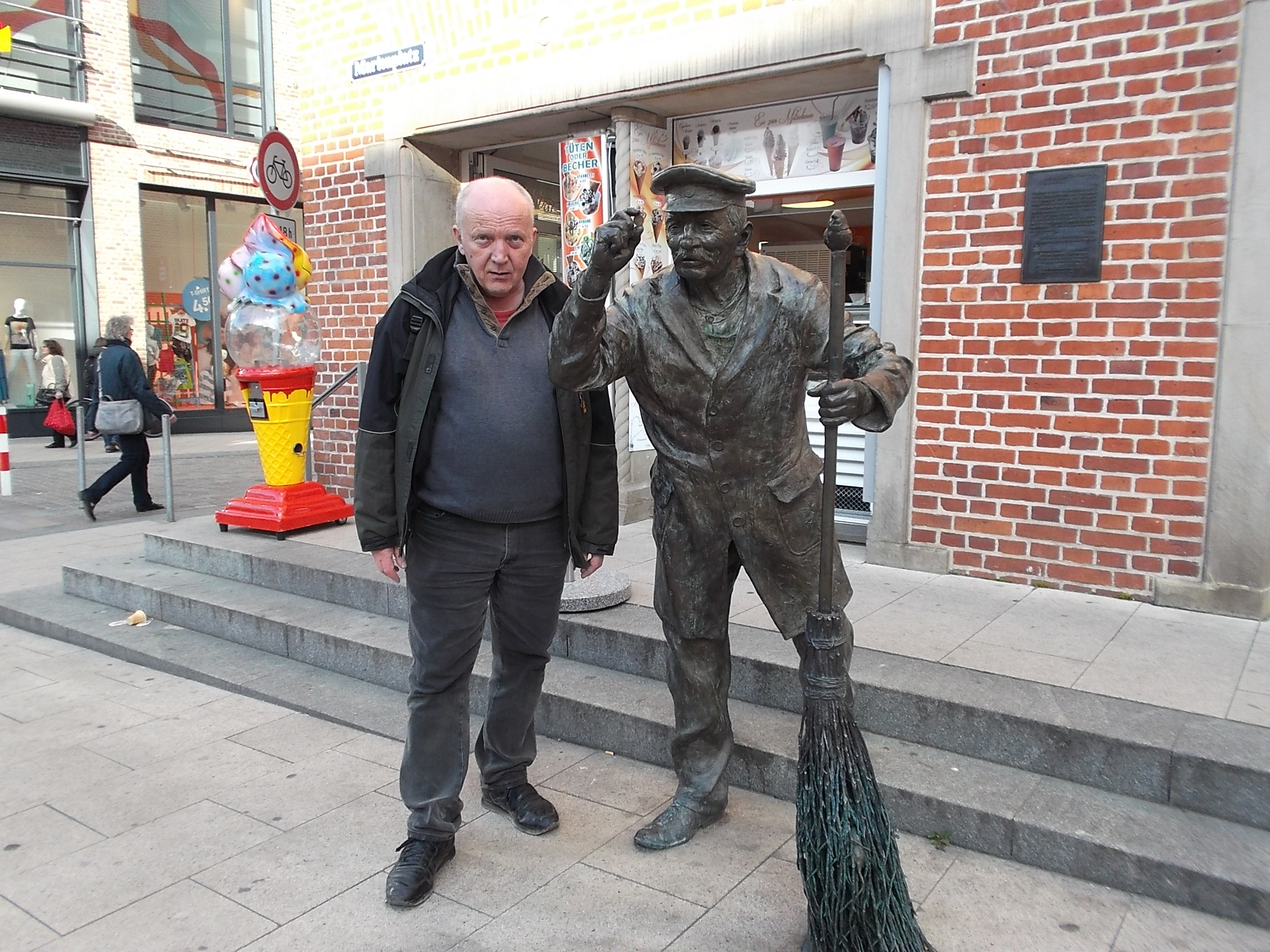 Farbfoto: Erwin Thomasius links neben dem Kunstwerk AUGUST FELTEN FIND'NEN GROSCHEN des Künstlers Bernd Streiter auf dem Marienplatz in der Altstadt von Schwerin in Schwerin am Donnerstag, dem 16. April im Jahre 2015. Fotograf: Bernd Paepcke.